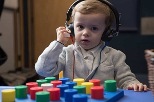 A child having a gentle, play-based hearing assessment with an audiologist