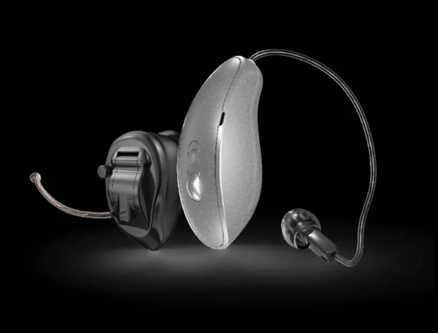 A modern receiver-in-canal hearing aid alongside its charger case